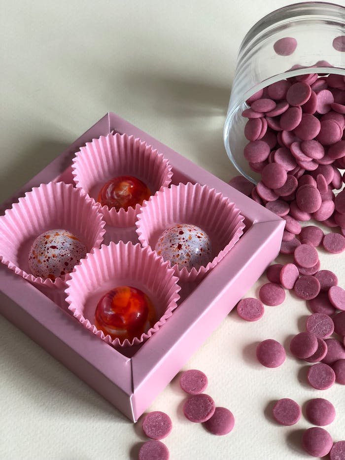 services-03 Stylish gourmet chocolates in a pink box with decorative wrappers, perfect for gifting.
