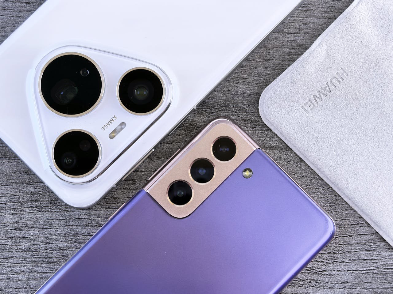 who-we-are Close-up of two smartphones with camera focus on a textured wooden surface.